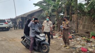Satpol PP Kabupaten Tangerang membagikan masker untuk warga sekitar TPA Jatiwaringin, Rabu 1 Juli 2026.