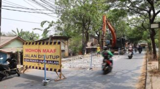 Petugas DPUPR Kota Tangerang menghancurkan jalan menggunakan metode breaking/demolition dengan alat berat di Jl. Marsekal Suryadarma, Neglasari, Kota Tangerang.