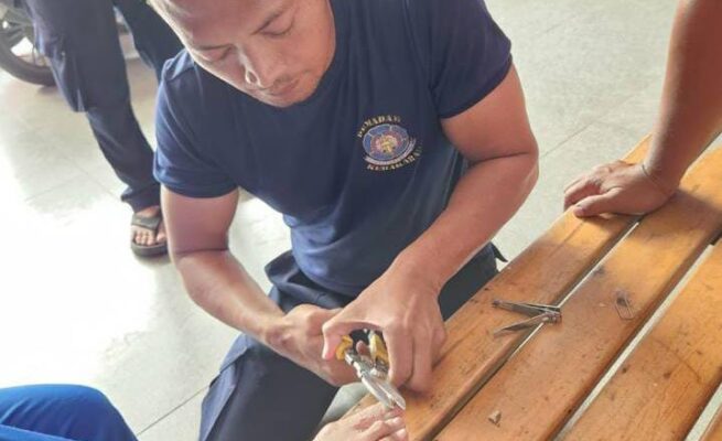 Petugas UPT Damkar Ciledug membantu memotong kuku jempol kaki kanan Salwah, 73, yang mengalami penebalan hingga 2 cm.