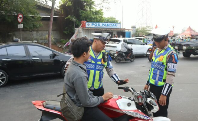 Personel Satlantas Polresta Tangerang memberhentikan pengendara yang tidak mengenakan helm dalam Operasi Patuh 2026.