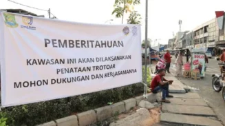 Spanduk pengumuman pembuatan trotoar di Jalan Kiasnawi, Kota Tangerang.